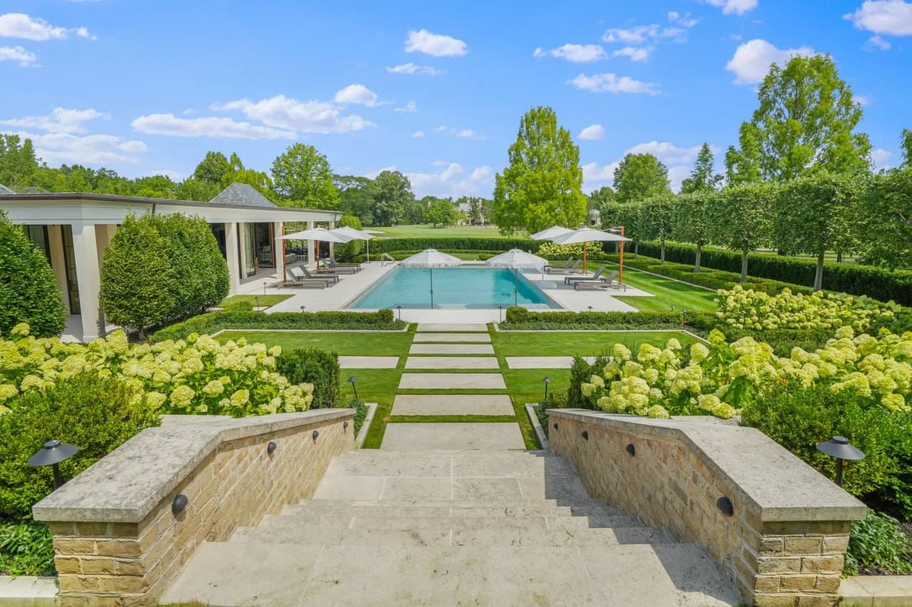 West Michigan estate — manicured pool garden with formal hedges, stone path, and pool house